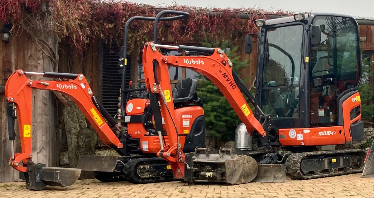 Ein Microbagger und ein Minibagger mit Kabine von Kubota, beide in Orange, stehen nebeneinander.